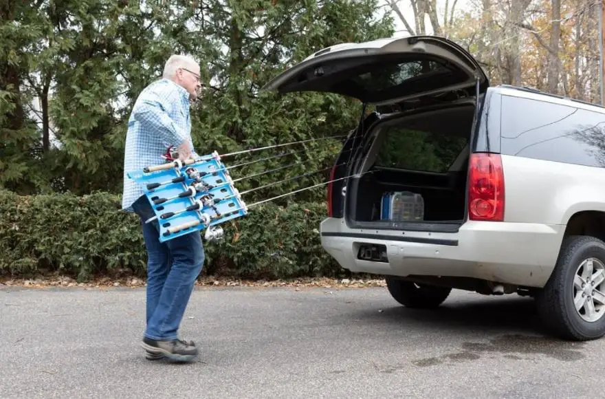 multiple fishing rod lengths stored in the back of the car