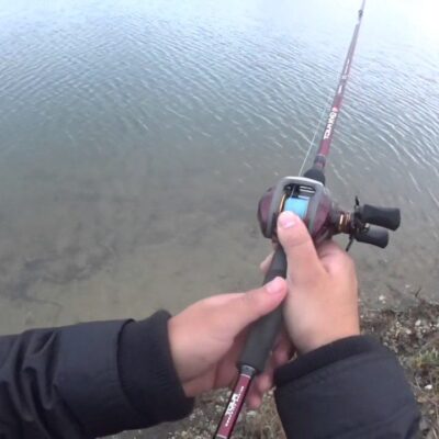casting a baitcaster reel into a lake