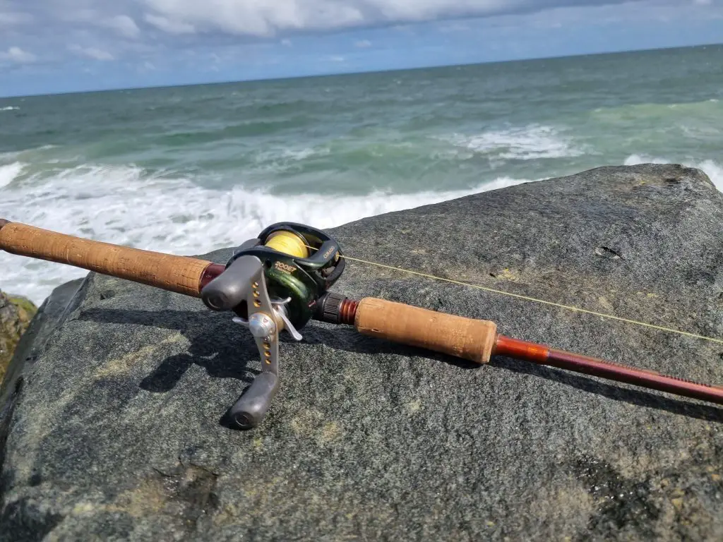 A Shimano Curado 200E7 spooled with 20 lb braid line in front of the ocean from the shore