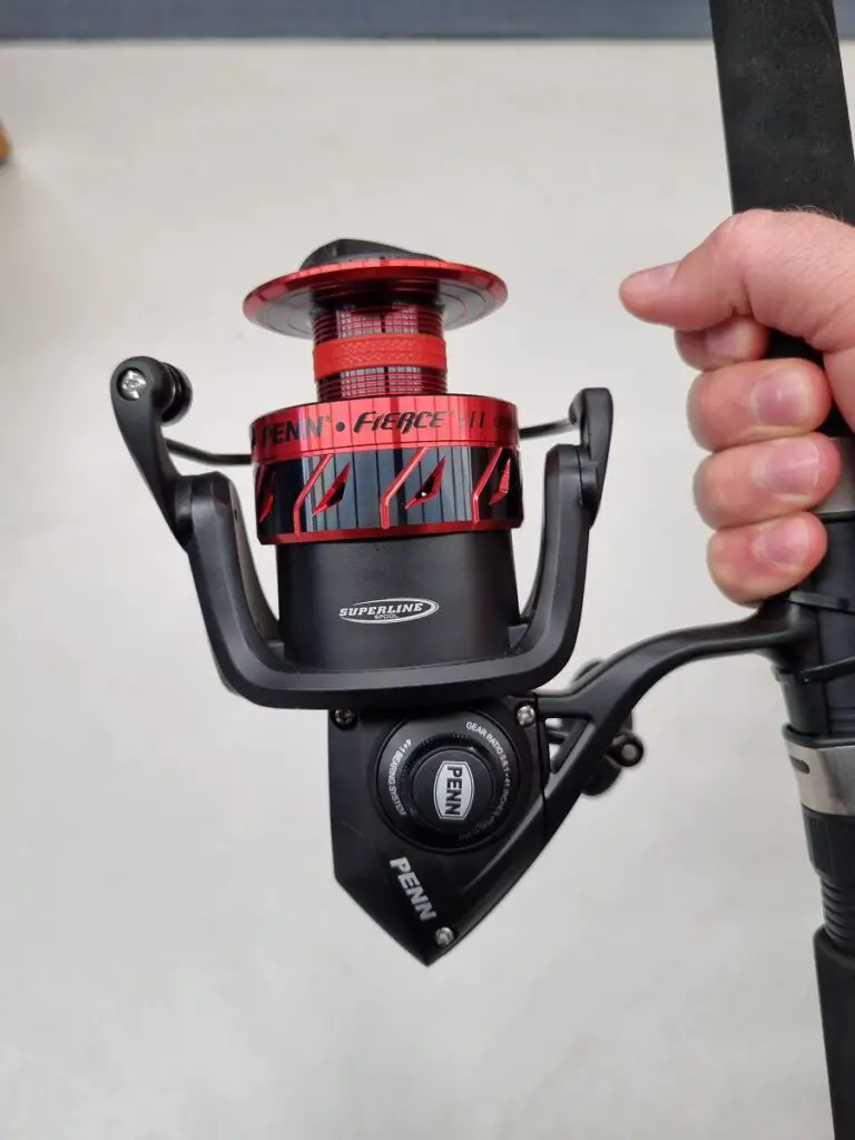 Showing the reverse side of a spinning reel and the screw to undo to release the handle